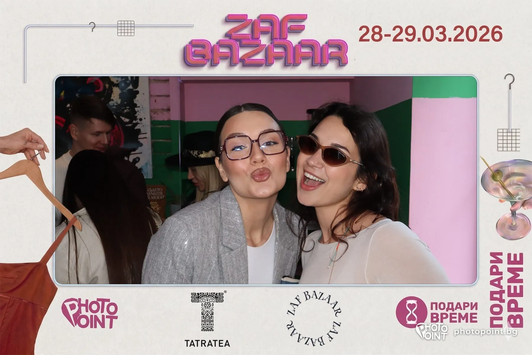 Two girls blowing kisses in a photo frame at a bazaar