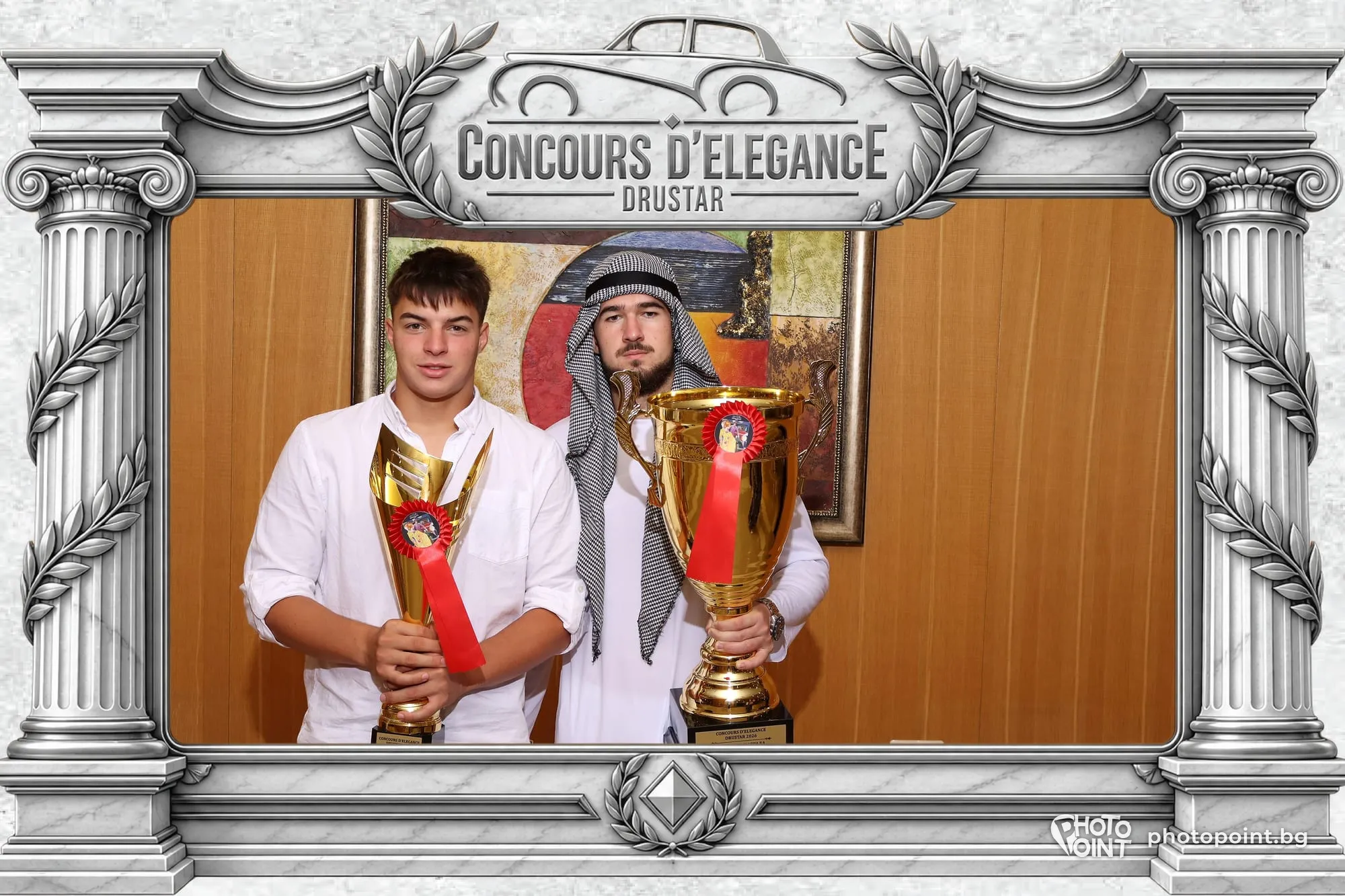 Two guests with trophies in a photo frame at a car show