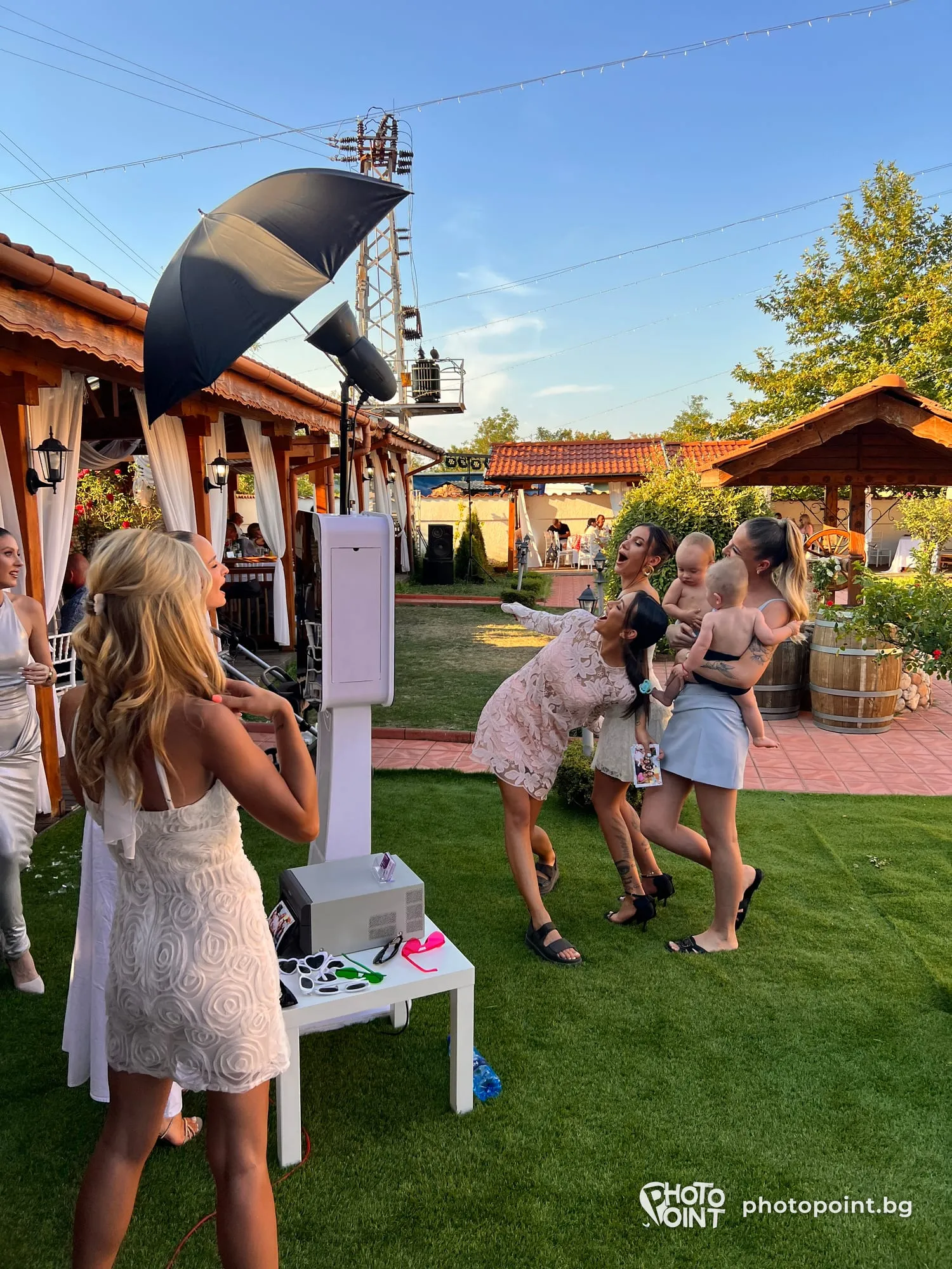Guests posing in front of PremiumPoint at an all-white party